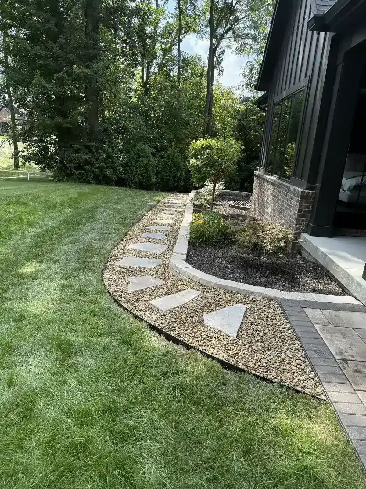 Decorative stone path and gravel bed beside a modern home, serving Zionsville, IN